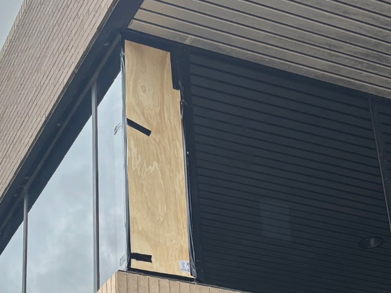 Commercial window opening secured with a temporary board-up.