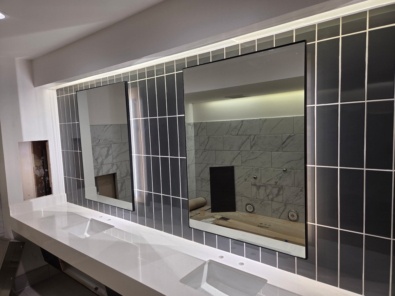 Pair of restroom vanity mirrors with overhead lighting.
